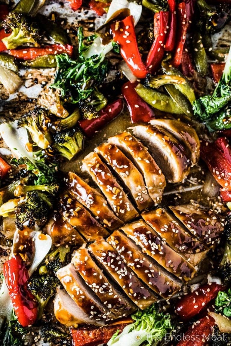 asian-chicken-sheet-pa Sliced chicken bread cooked on a sheet pan with veggies and sauce.