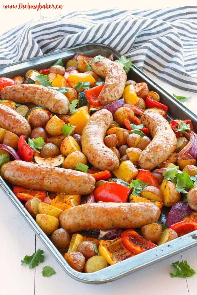 italian-sausage-sheet-pan-1 Italian sausage in sheet pan cooked with tomatoes, potatoes, bell peppers and onion.