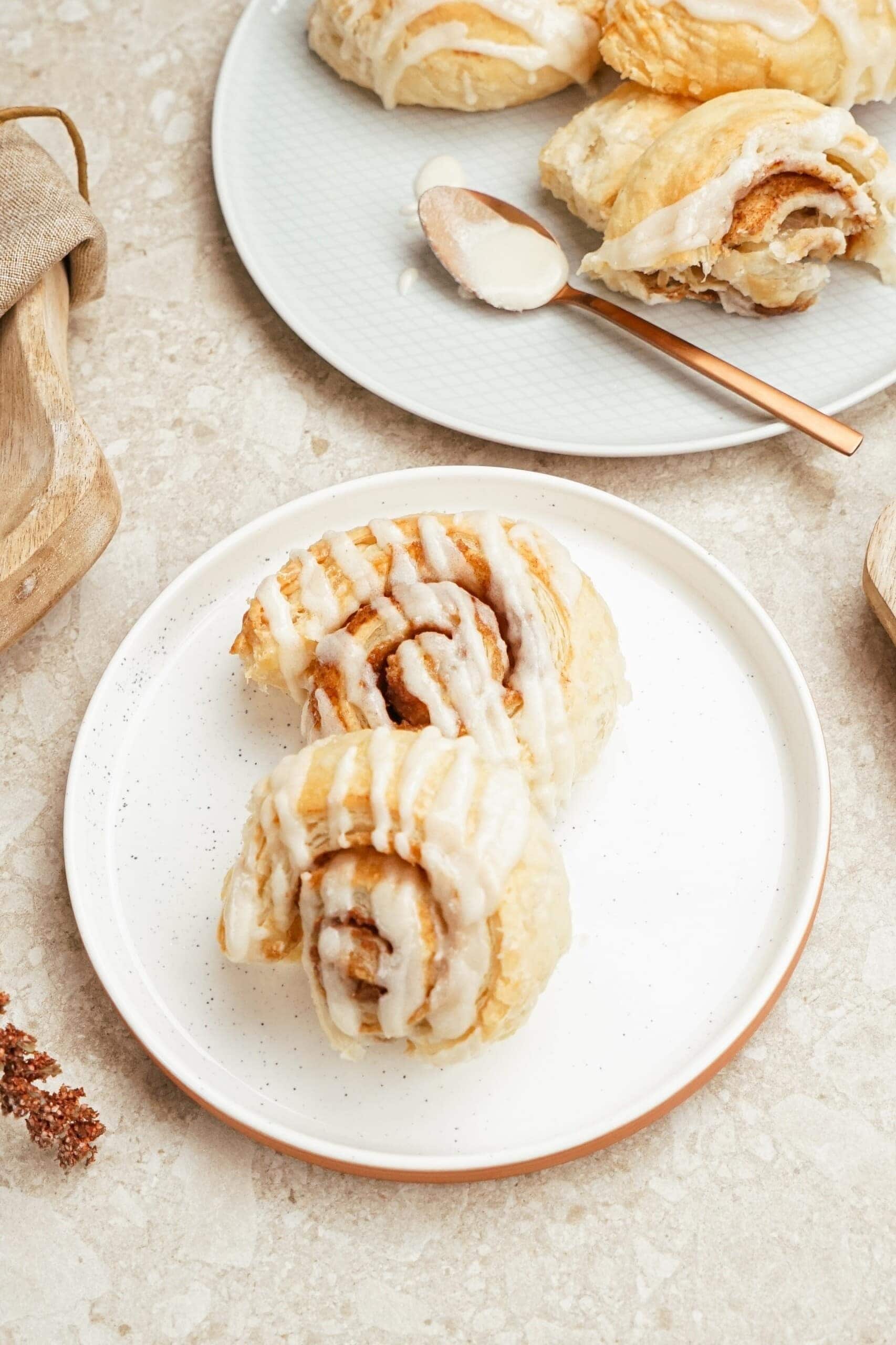 Cinnamon rolls with sugar glazed toppings served on plates.