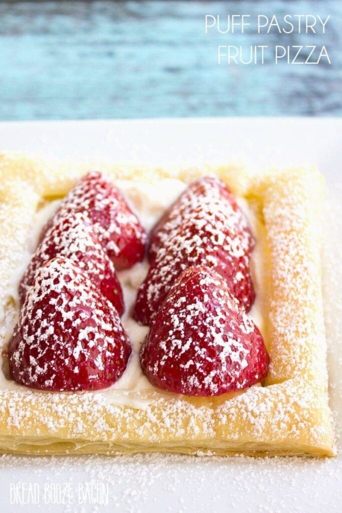 Pizza pastry topped with strawberries and dusted with powdered sugar.
