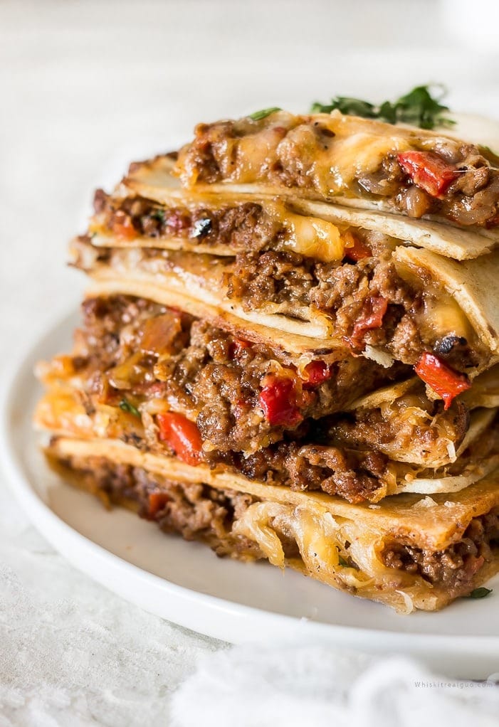 quesadillas-in-the-oven-sheet-pan Sliced quesadilla on a plate cooked in a sheet pan.